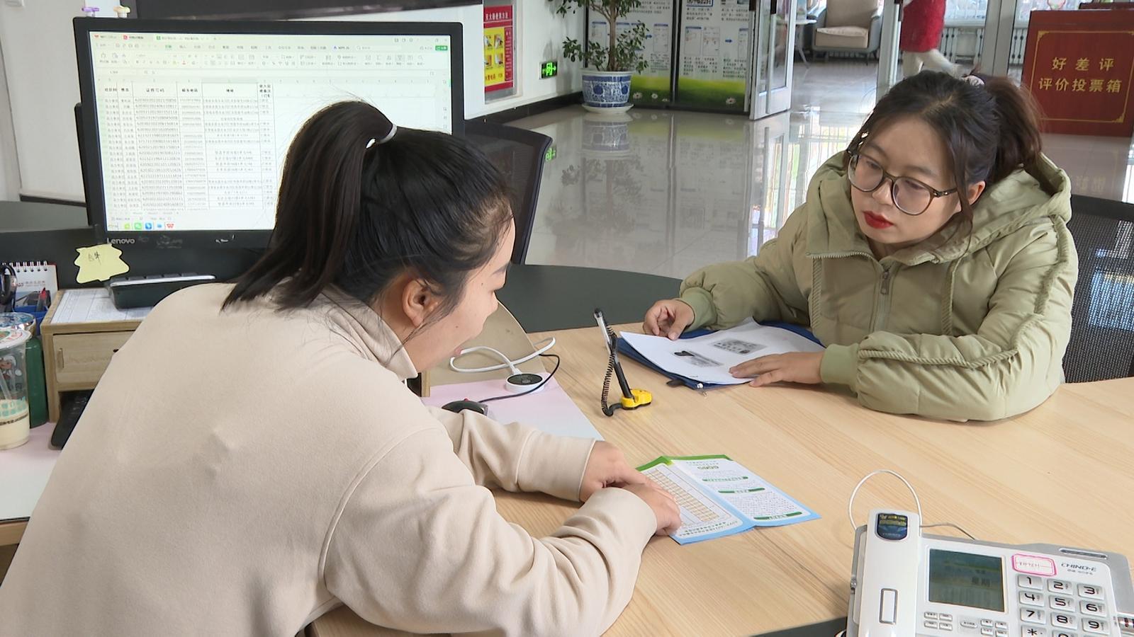 △昌丰里社区服务大厅工作人员为居民李玉汝讲解国家育儿补贴的申领政策