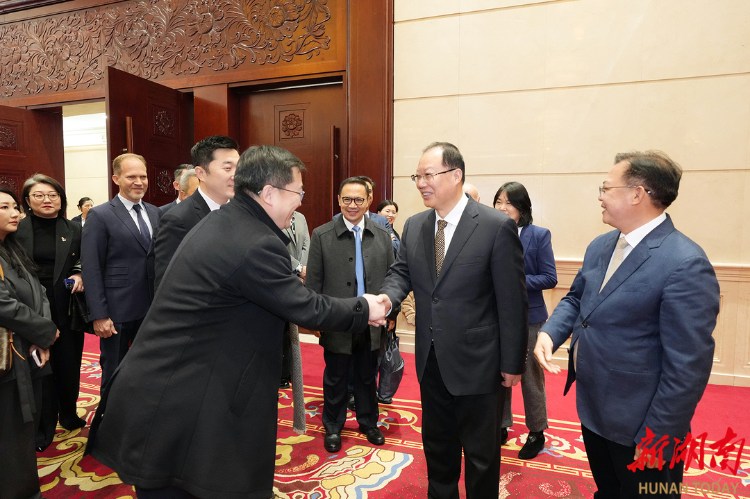 毛伟明与与会代表握手。