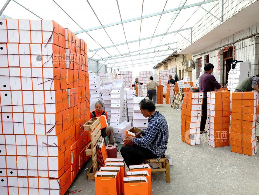 村民在家门口有序制作鞋子包装盒。