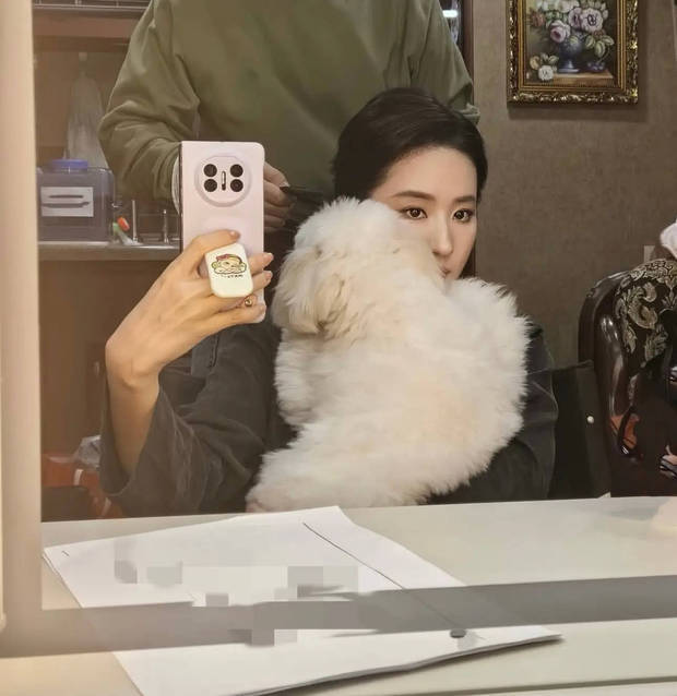 搜狐娱乐讯 1月6日，刘亦菲在社交平台分享一组随拍，照片里的她抱着小狗，对镜自拍，状态松弛。