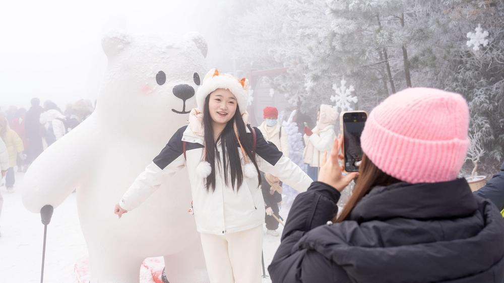 游客在冰雪体验中心与玩偶合影留念。