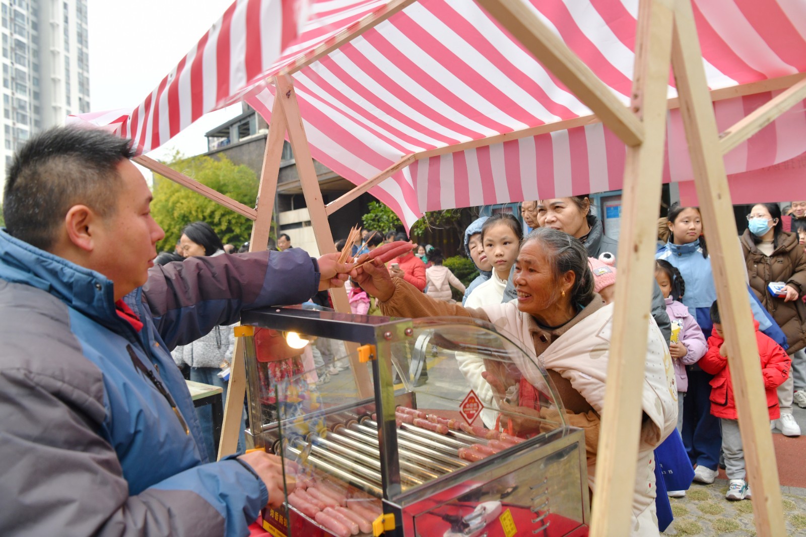 居民排队免费领取烤肠。
