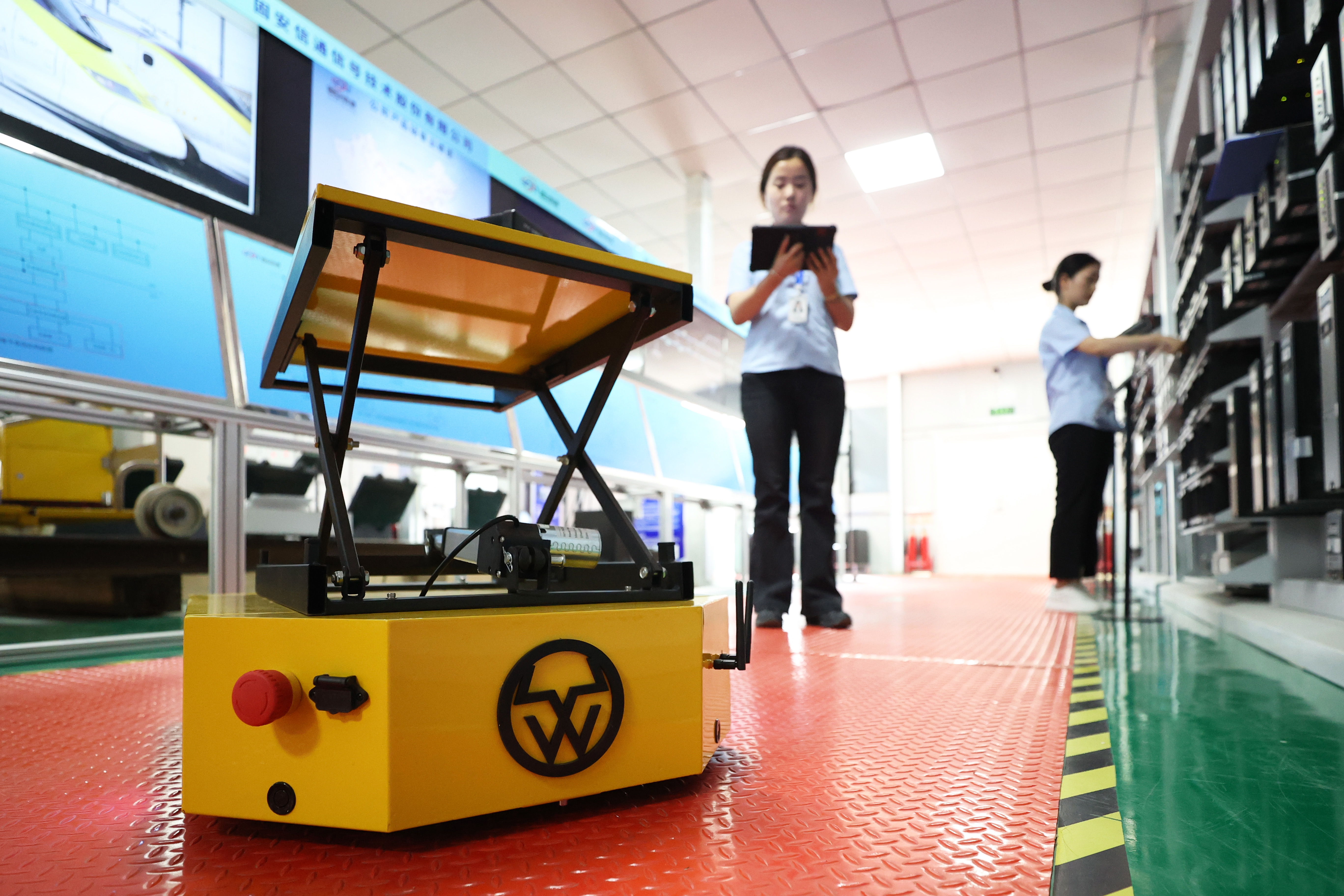 固安信通信号技术股份有限公司工作人员正在利用巡检机器人搬运实验设备。（资料片）贾珺摄