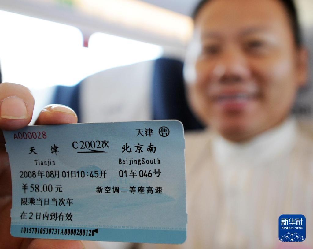 2008年8月1日，一名乘客在天津开往北京的京津城际列车上展示当日当次车票。新华社记者 王晔彪 摄