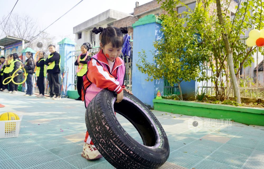 2026年1月4日，江西遂川县珠田镇育苗幼儿园里热闹非凡，一场亲子互动趣味运动会欢乐开启。萌娃们抱着篮球闯关卡：推轮胎、过木梯、翻垫子，动作利落又可爱；家长们手持彩圈助威，现场笑声与掌声交织。