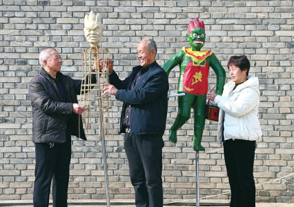 王成林（左）与杨民杰（中）、王娟共同制作“独占鳌头”上的魁星。