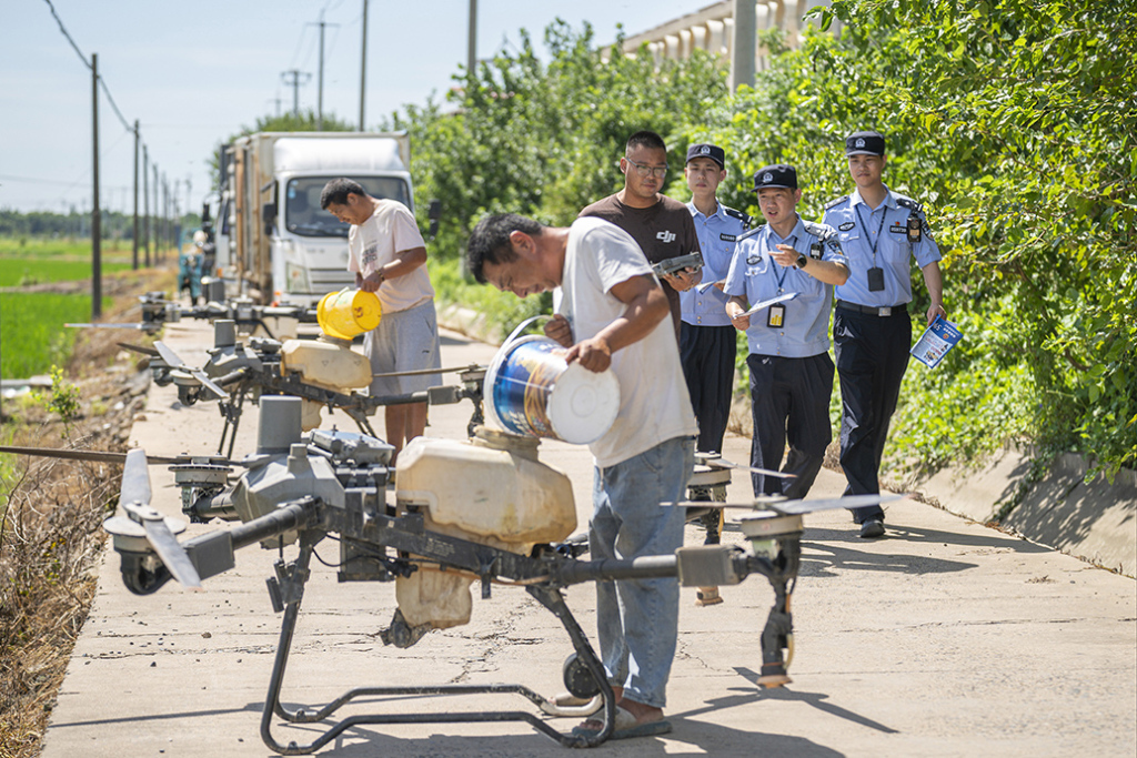 崇明公安分局新海派出所民警深入田间地头，引导无人机飞手依法依规操作农用无人机，确保农忙期间生产安全有序 。 上海市公安局 供图