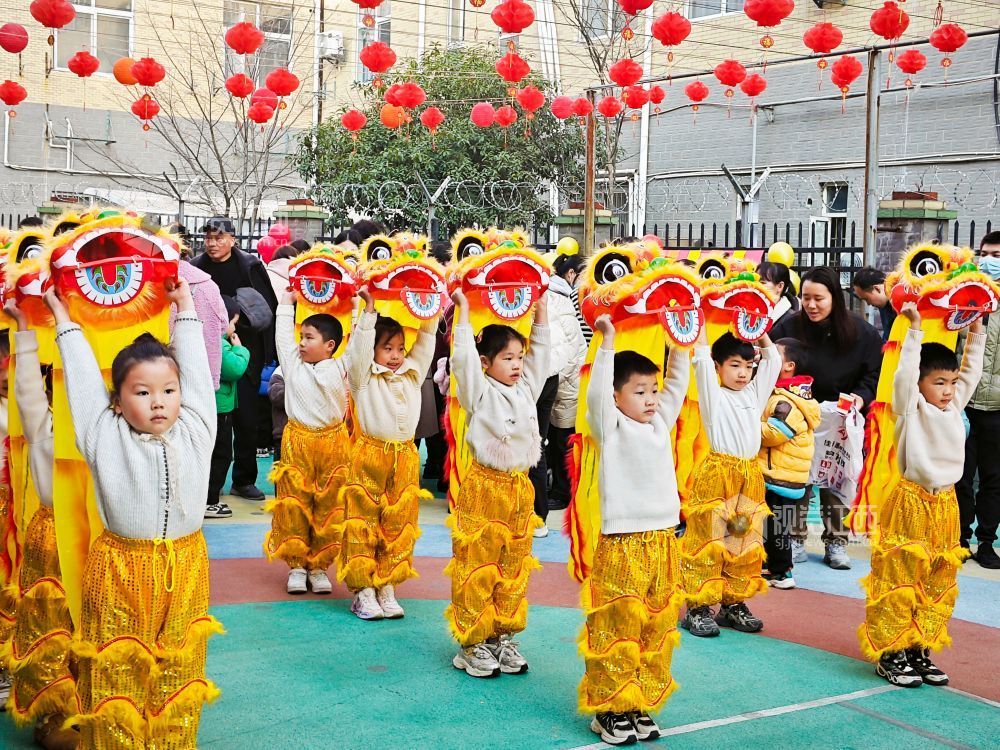 小朋友在幼儿园内舞龙舞狮，喜迎新年到来。