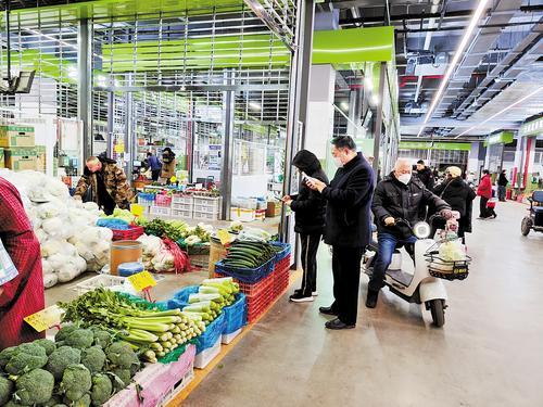 1月12日，在石家庄市白佛民生广场，附近的居民在购买蔬菜。 本报记者 赵泽众摄