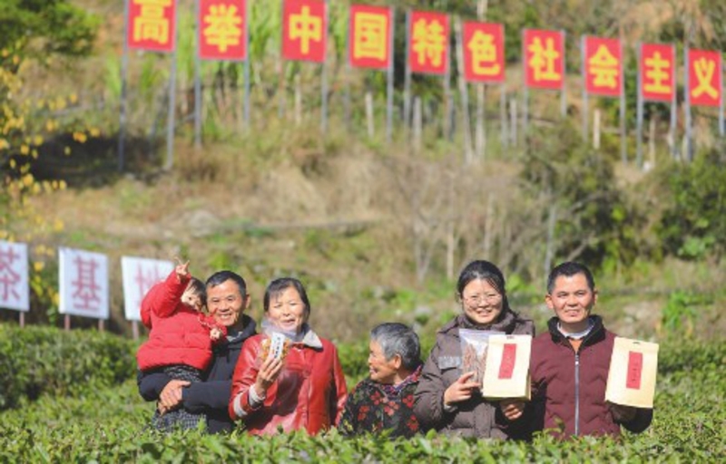 在神山村的茶叶基地,村民彭德良和家人展示村里的农特产品茶叶、笋干、黄桃干。