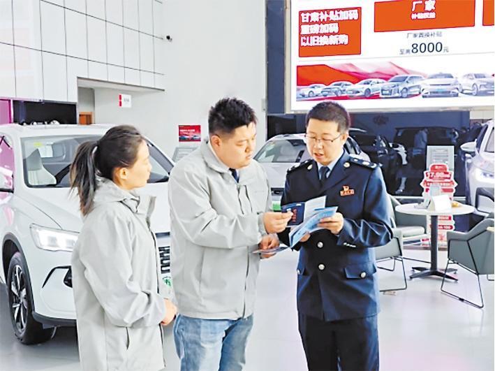 凉州区税务局干部向汽车4S店工作人员宣传车辆购置税政策　甘肃省税务局供图