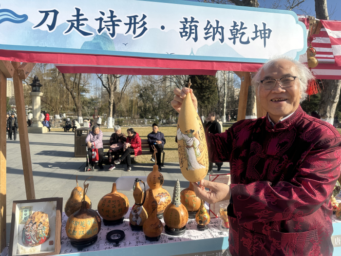 陕西省非遗文化关中葫芦刻画技艺代表性传承人梁平安展示刻有唐诗的作品。张思思 摄