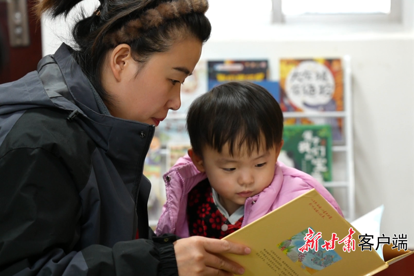 母亲正在给女儿讲绘本故事