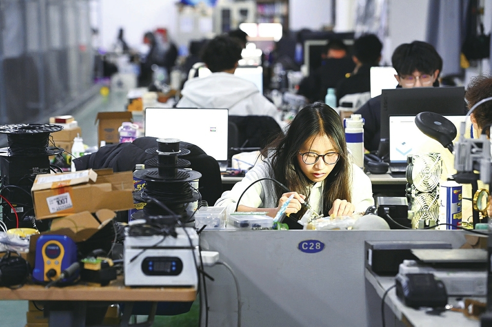 徐秀云正在进行自主研发的开发板焊接工作。