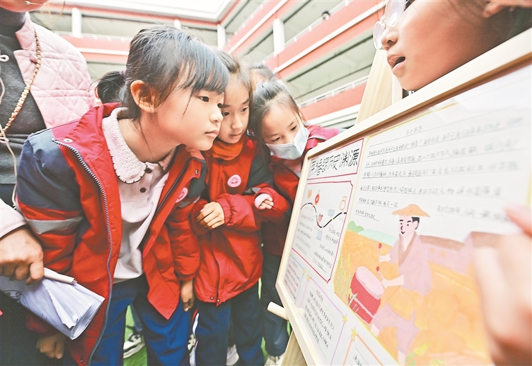 2025年12月22日，萍乡市湘东区湘东镇，同学们正在观看萍乡春锣主题的手抄报作品。