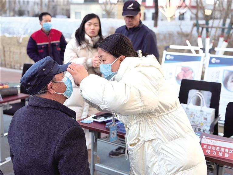 家政志愿服务人员对市民进行视力检查