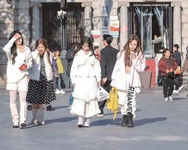 武汉街头暖意融融 行人薄衫与棉服同框