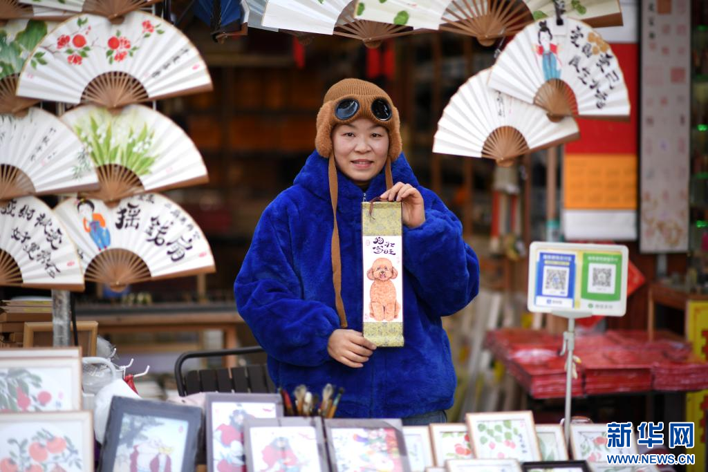 1月9日，画师陈丽华在西安书院门历史文化街区展示自己绘制的宠物狗画像。