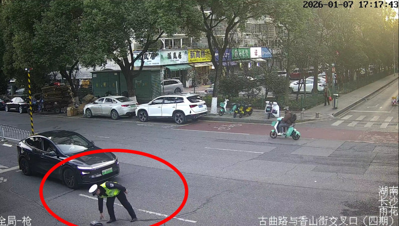 胡龙拾取掉落在街上的现金。