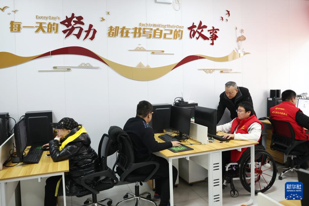 在兰州市心连心社会工作服务中心残疾人就业工坊,社会工作者王生番(后右二)指导残疾人AI训练师进行数据标注工作(1月14日摄)。新华社记者 陈斌 摄