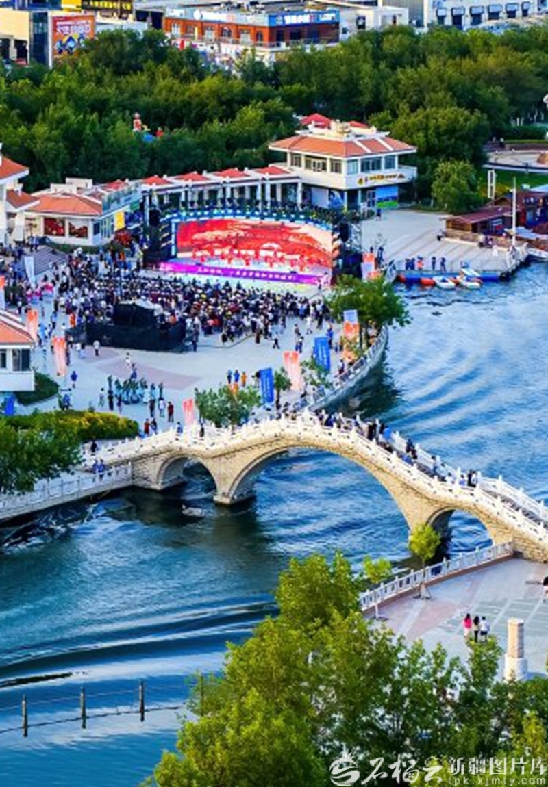 克拉玛依河景区华灯初上、夜景璀璨，吸引了众多纳凉的市民和游客驻足观赏（2025年7月24日摄）。 闵勇摄