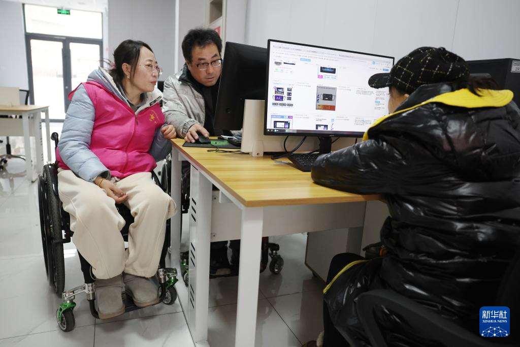 在兰州市心连心社会工作服务中心残疾人就业工坊,AI训练师邵永妮(左一)和许小刚(左二)进行数据标注工作(1月14日摄)。新华社记者 陈斌 摄
