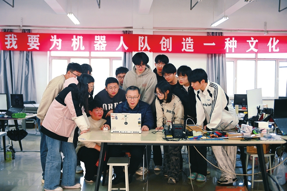 团队负责老师左义海与团队成员共同研究新发布的赛事规则。