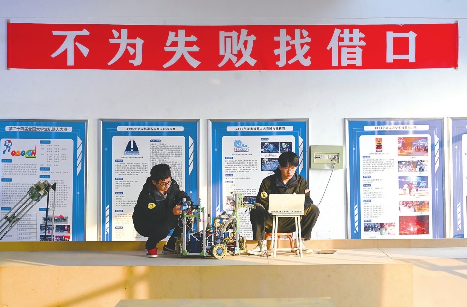 大二年级队员张越博（左）与庆正业正进行下一赛季机器底盘调试。