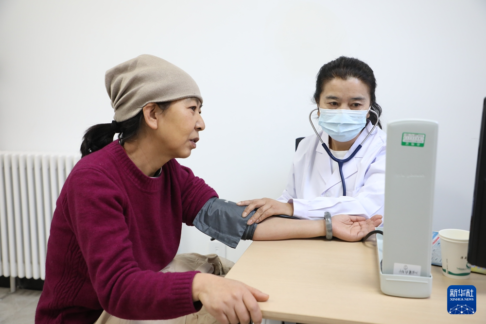 1月17日，在甘肃省漳县人民医院门诊，白银市第二人民医院副主任医师李月华（右）为当地患者义诊。新华社记者　张智敏　摄