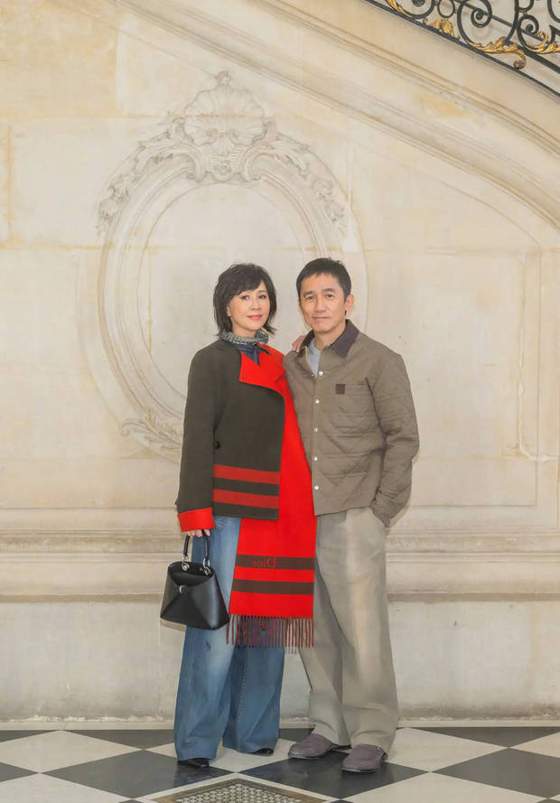 刘嘉玲梁朝伟二人倚墙而立，举止亲密。