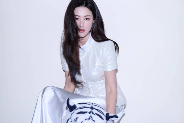 朱珠白亮片上衣搭缎面裙，手戴钻饰，姿态优雅松弛。