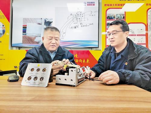一月七日，齐名（左）和同事讨论器件维修改进方案。本报记者 马彦铭摄