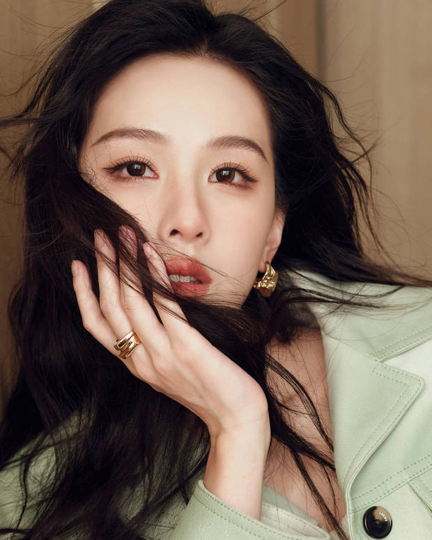 陈都灵以手托腮、发丝遮半脸，金饰耳坠与戒指点缀，眼神澄澈。