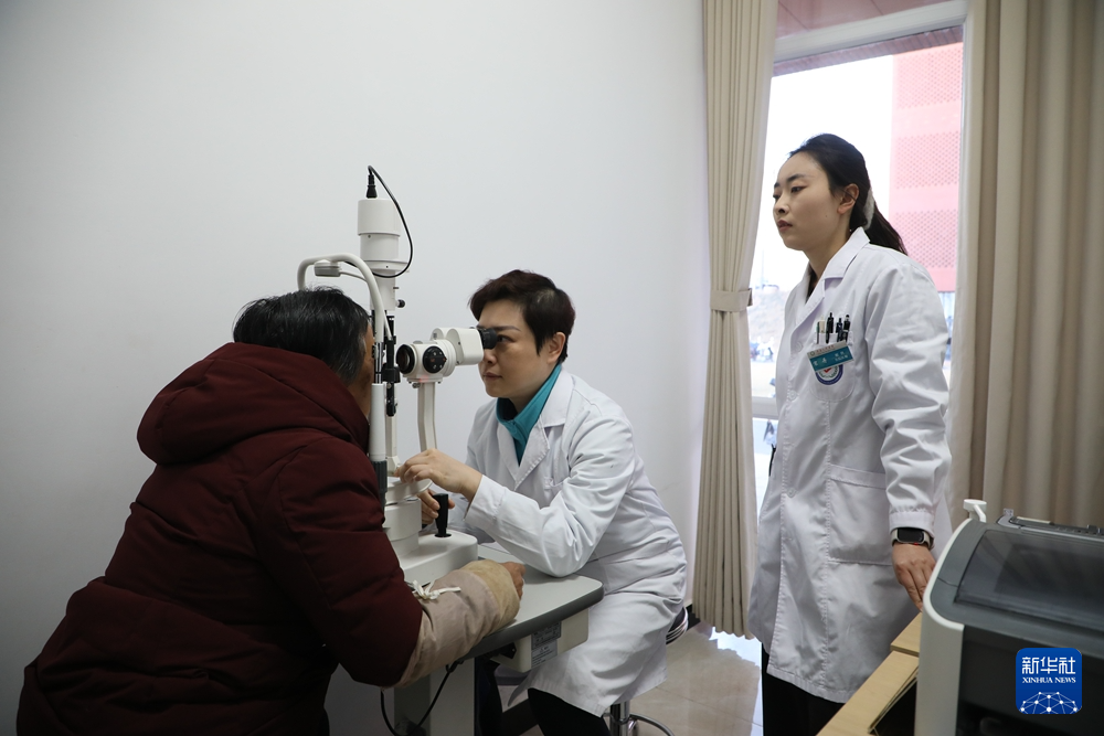 1月17日，在甘肃省漳县人民医院眼科门诊，首都医科大学附属北京同仁医院副主任医师侯芳（中）为当地患者检查眼疾。新华社记者　张智敏　摄