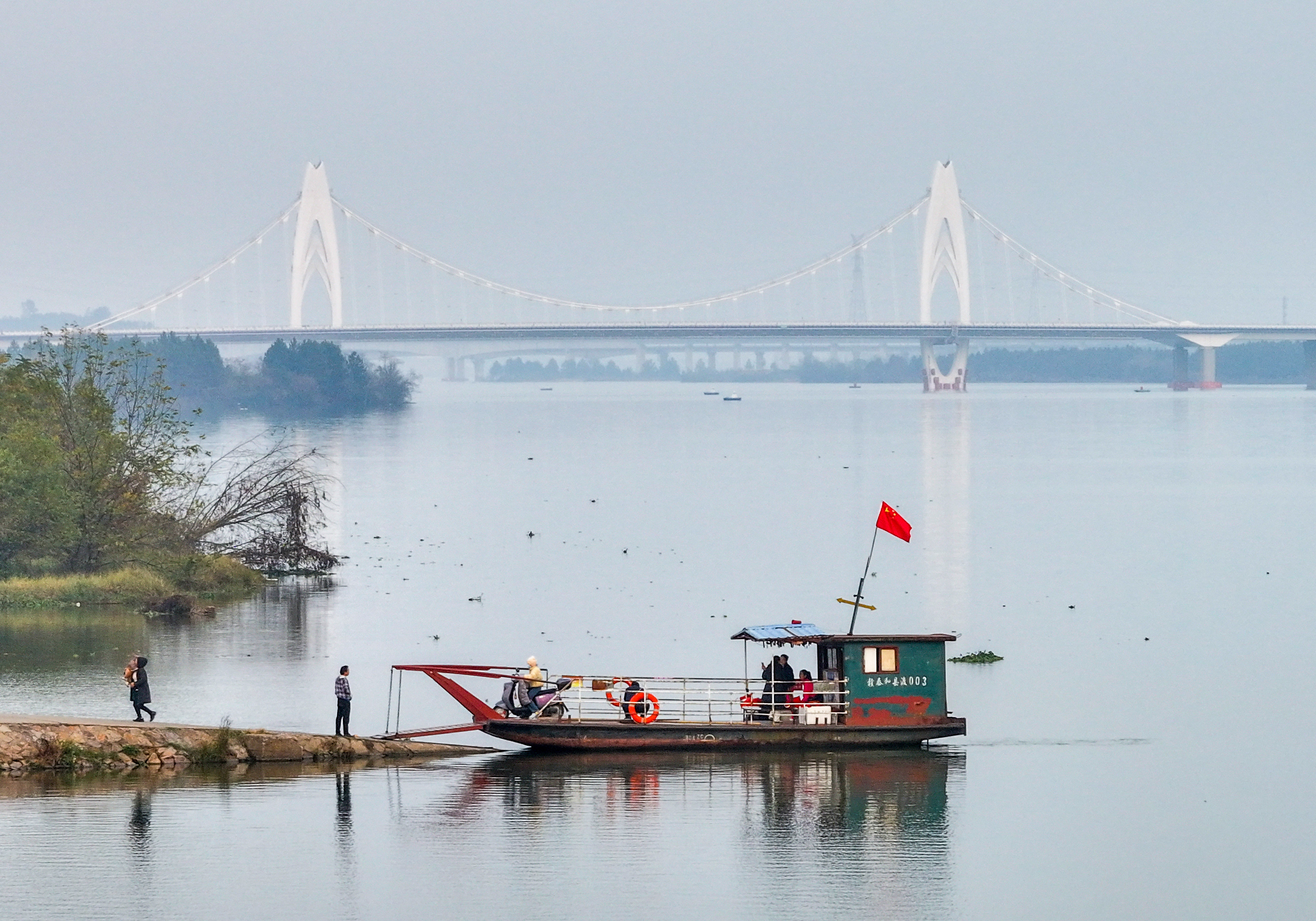 ▲2025年12月30日,泰和县永昌渡口,仍有不少乘客乘坐渡船过江。远处,澄江大桥横跨赣江,已于2025年12月29日通车。