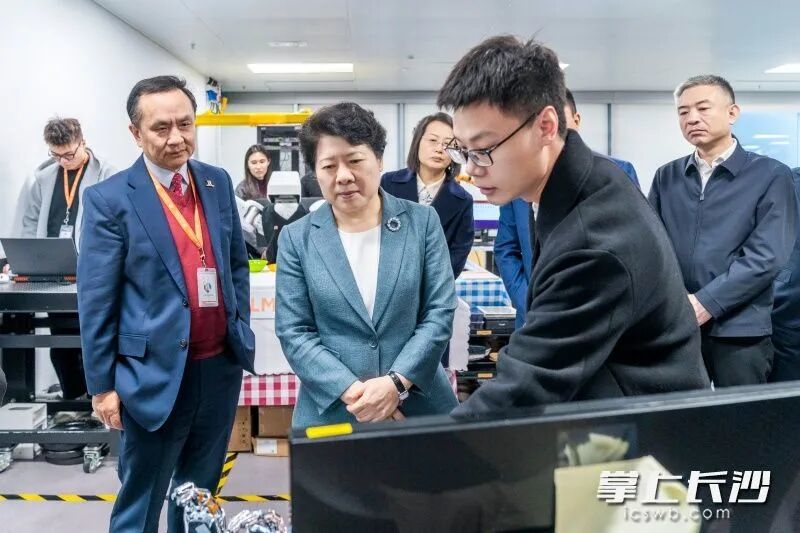 吴桂英在香港科学园,参观物流机械人研究中心。