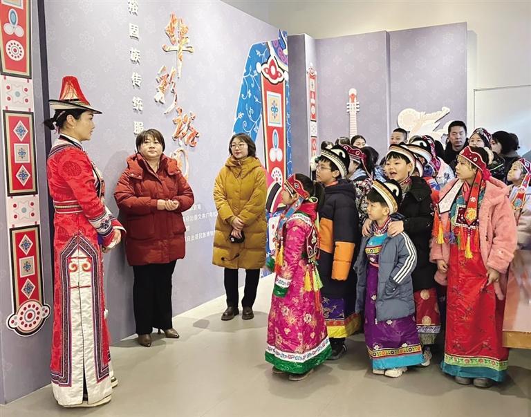 孩子们身着裕固族传统服饰,在兰州市博物馆参观“华彩裕固——裕固族传统服饰展”。