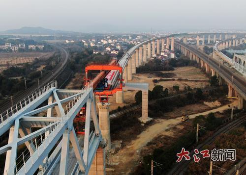 2025年12月30日，在昌九高铁乐化联络线架梁施工现场，施工人员正在架设最后一孔预制箱梁。 大江网视觉江西胡国林摄