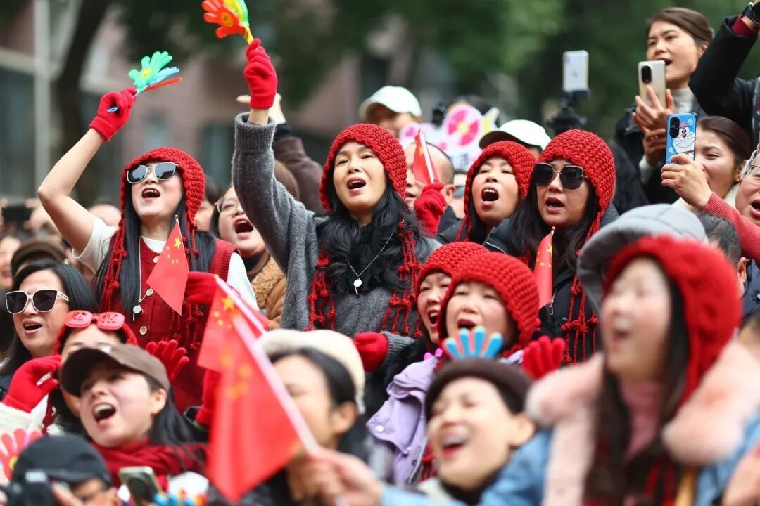 头戴红帽、系着红围巾的“钻石粉”在演出现场随着音乐挥手合唱。