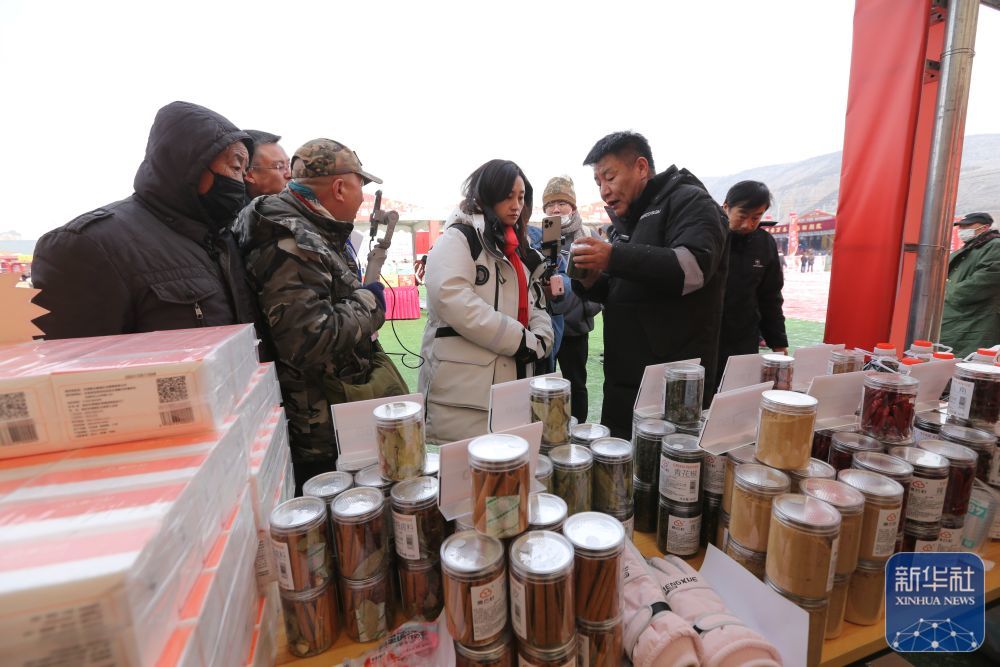一位摊主在年货大集上和自媒体博主一起推介当地特色农产品(1月19日摄) 新华社发 王克贤 摄