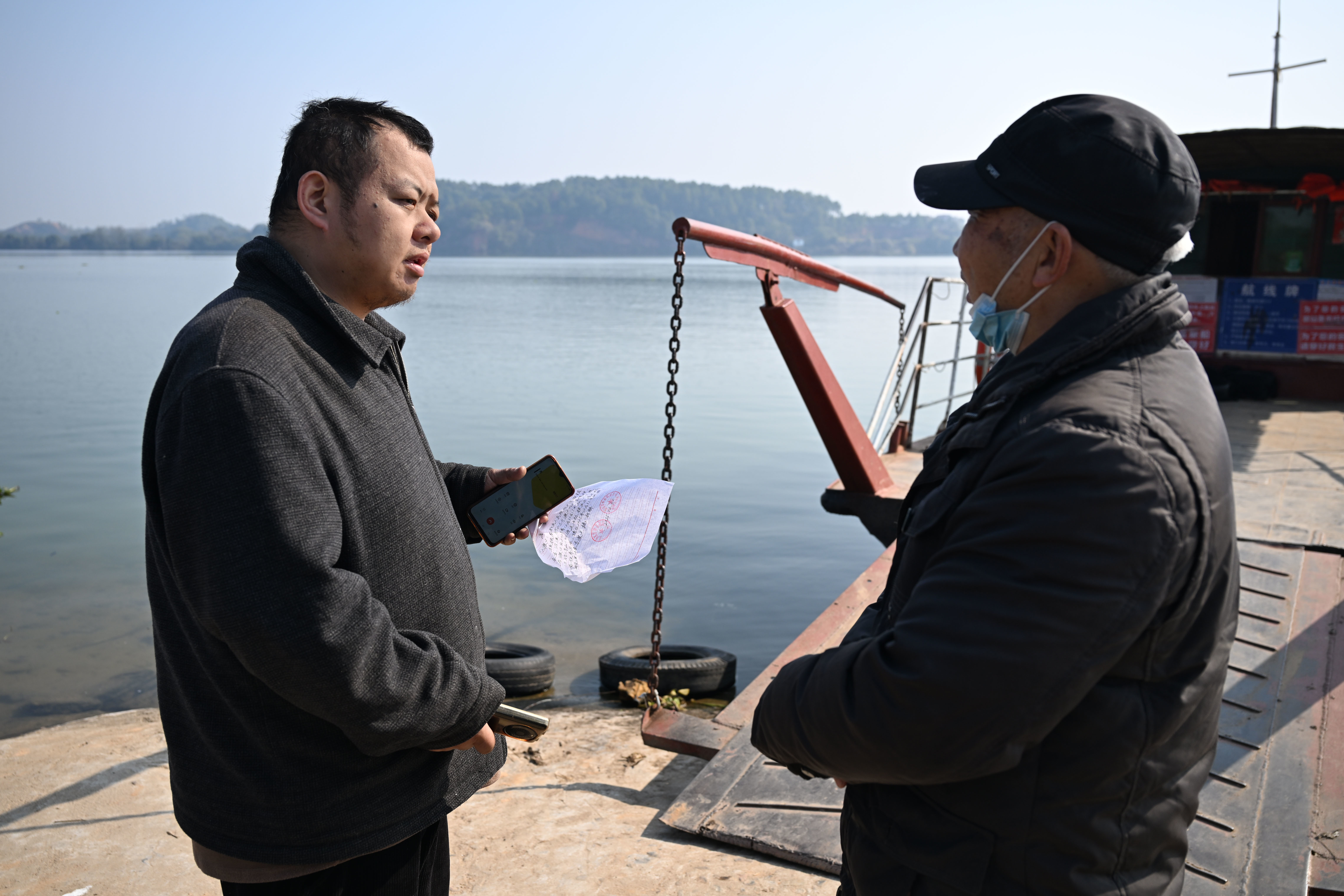 ▲12月30日,泰和县航运公司五大队老队长汤正荣(右)向曾健龙送来正式停运和撤渡通知。