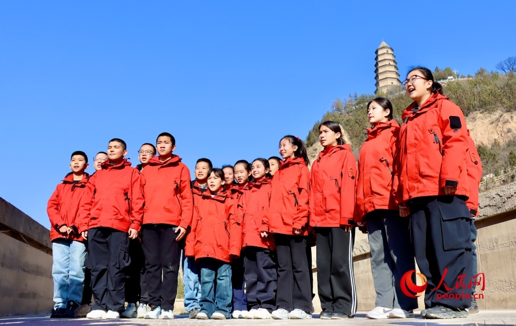 新疆学子在陕西延安宝塔山下朗诵诗歌《延安，我把你追寻》。人民网 李龙摄