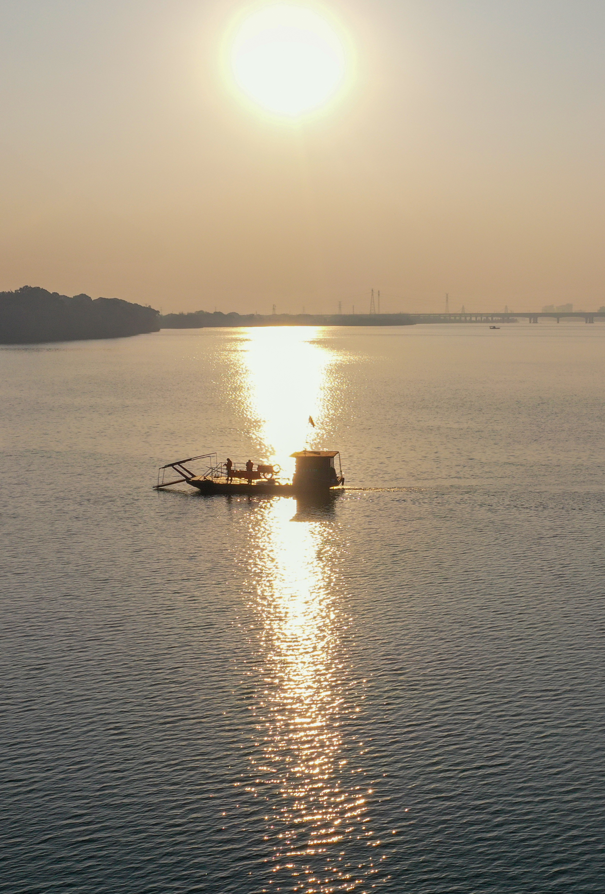 ▲2025年12月26日,沿溪渡口的渡船在夕阳下横渡赣江。