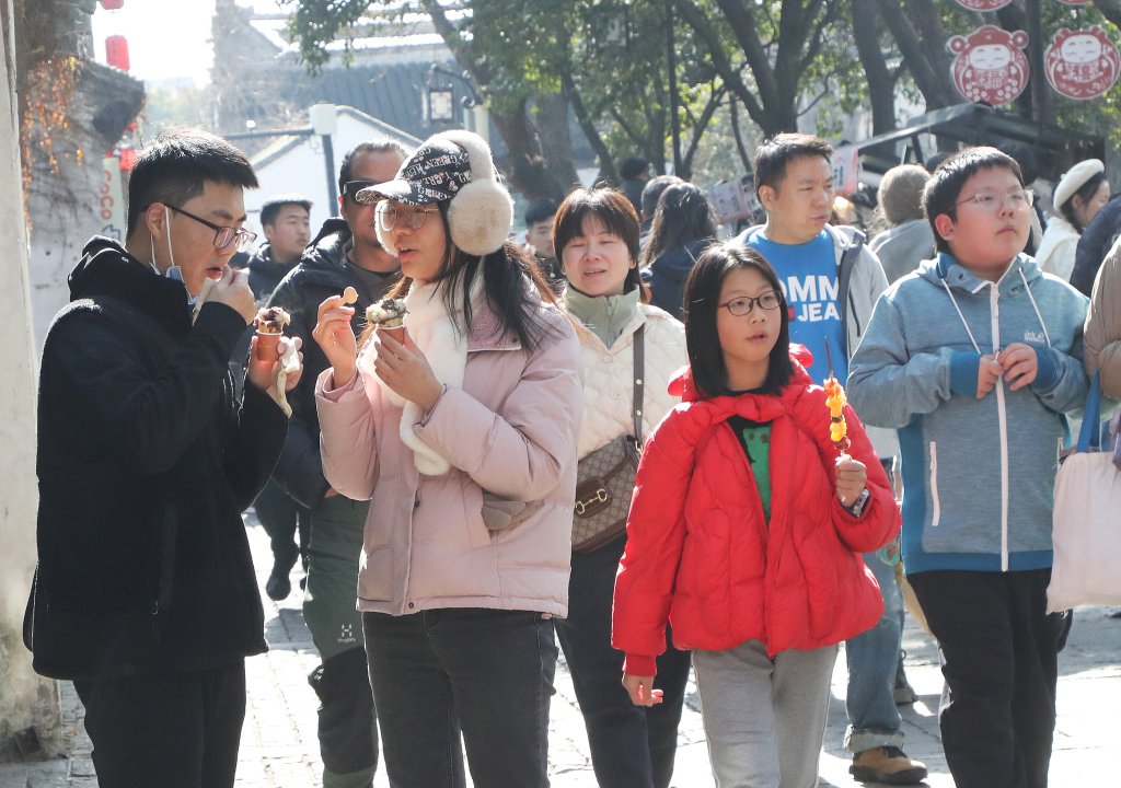 2025年1月18日,苏州,几名学生结伴在平江路历史街区漫步游玩。