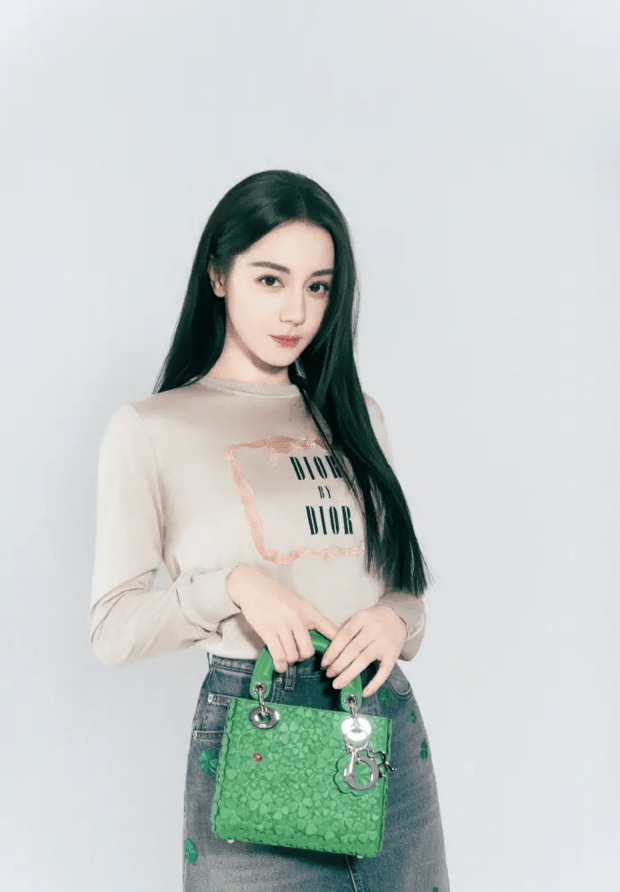 迪丽热巴双手握包，造型精致时尚。