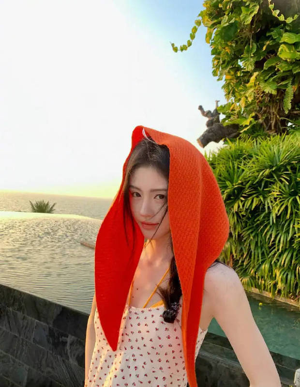 搜狐娱乐讯 鞠婧祎近日发布了一组以海边落日为背景的写真大片，身披红头巾在秋千上轻荡，橘色暮光与海风交织，营造出浓郁的夏日浪漫氛围。