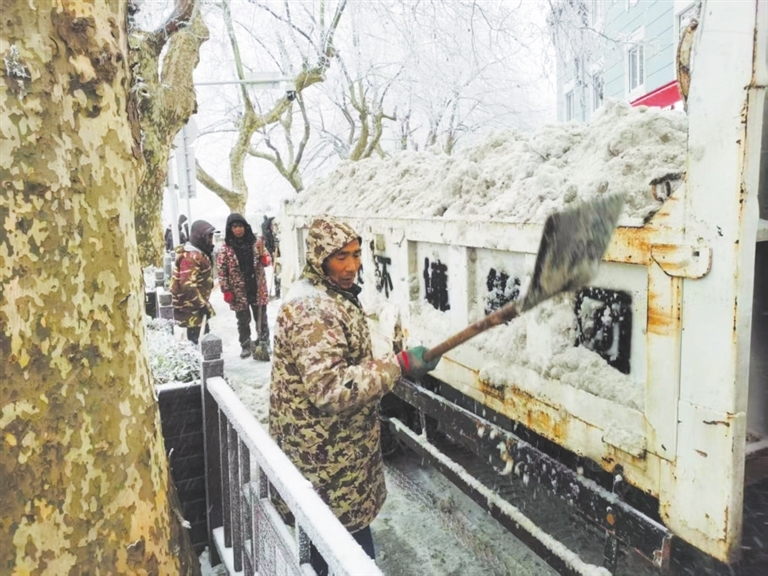 工作人员在牯岭正街除雪保障通行。（浔阳晚报记者 张新红 摄）