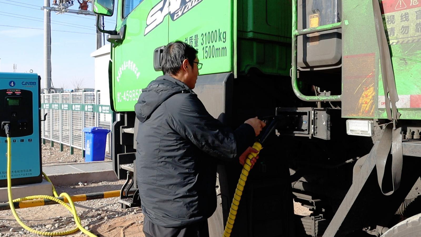 △司机师傅正在为新能源重卡连接充电枪