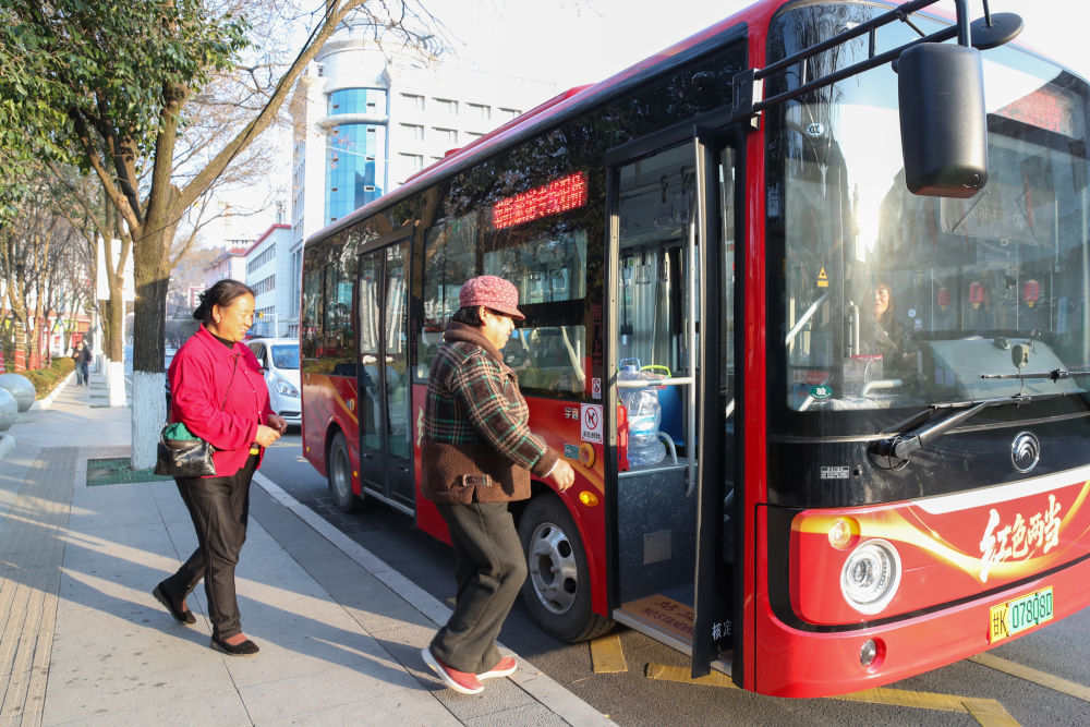 1月17日,在甘肃省陇南市两当县一处站点,2名老人乘坐免费公交。新华社记者 郎兵兵 摄