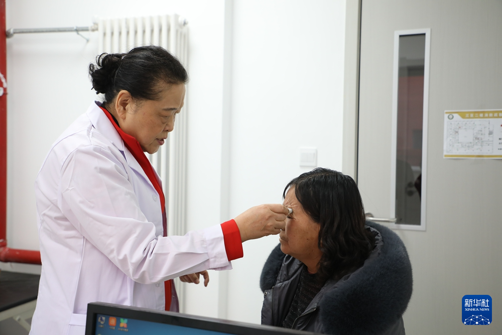 1月17日，在甘肃省漳县人民医院，中国女医师协会副会长侯惠荣（左）为当地患者进行义诊。新华社记者　张智敏　摄